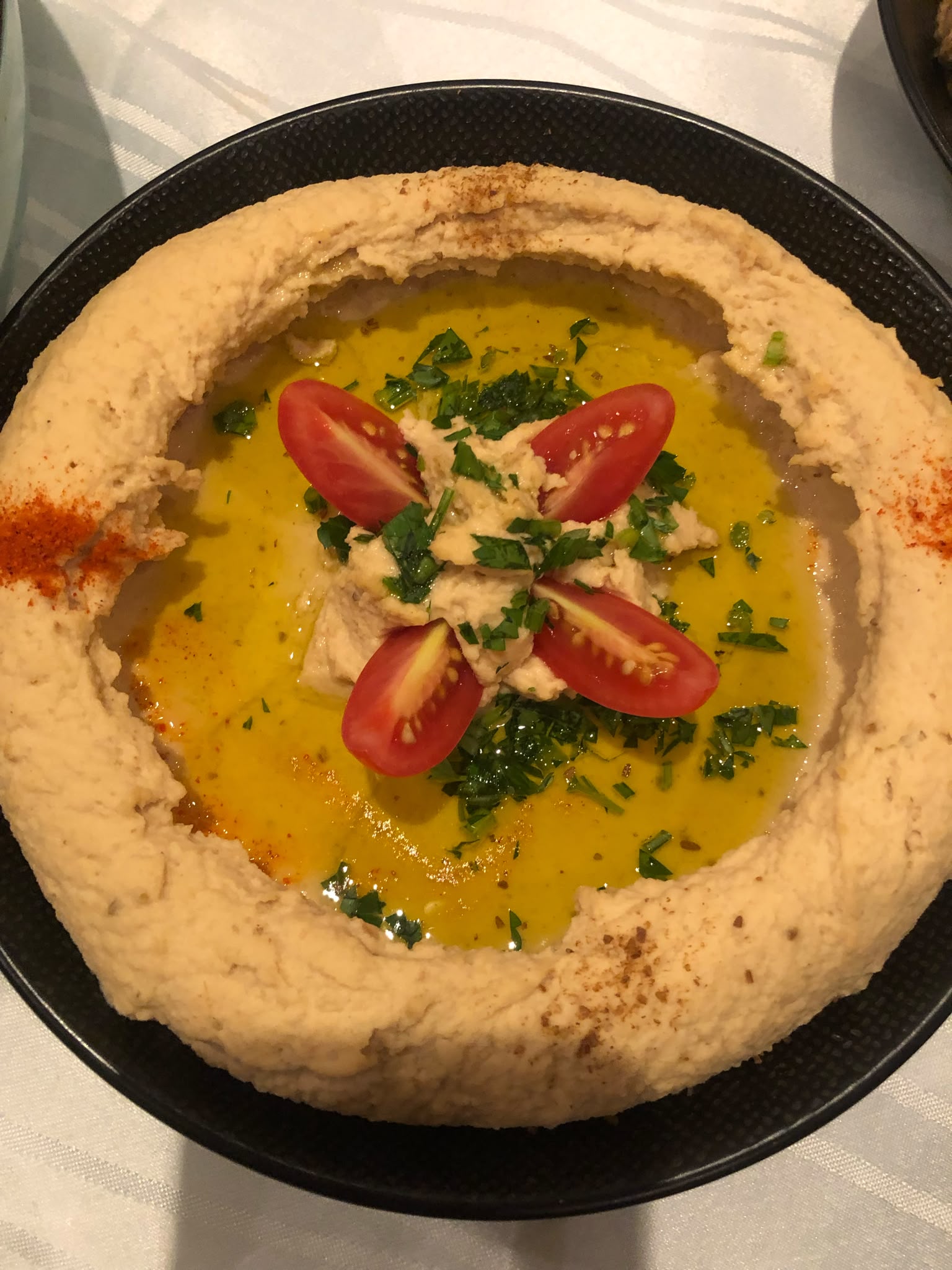 Hummus mit Olivenöl, Tomaten und Petersilie, im Mezze-Kochkurs selbst gemacht